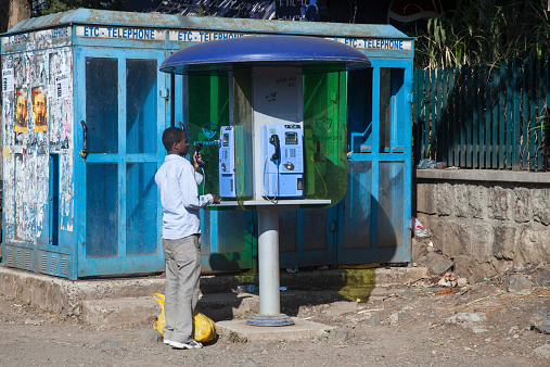Addis Abeba, Ethiopia - November 16, 2011: The man speaks by public telephone, Ethiopia.