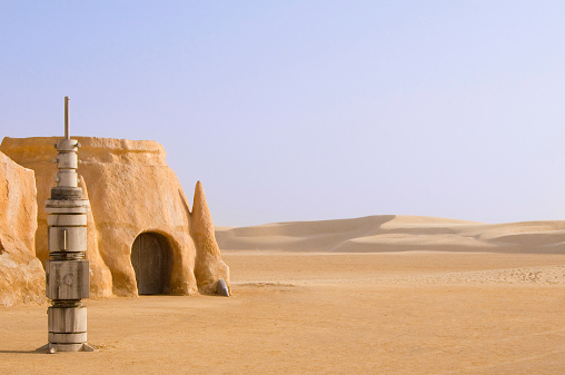 Abandoned sets for the shooting of the movie Star Wars in the Sahara desert on a background of sand dunes.