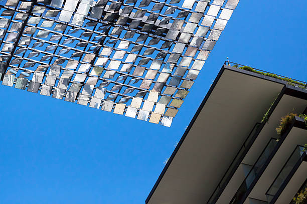 Low angle view of Heliostat against blue sky, copy space Low angle view of heliostat of motorised mirrors on high rise building Sydney Australia against blue sky, full frame horizontal composition, with copy space concentrated solar power photos stock pictures, royalty-free photos & images