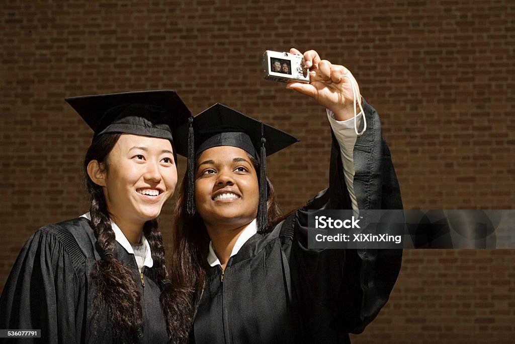 Two female graduates taking a photograph International Student Stock Photo