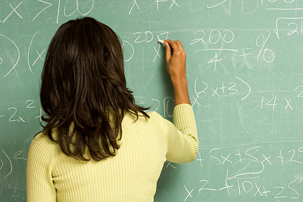 weibliche schüler schreiben auf tafel - mathematics mathematical symbol student teacher stock-fotos und bilder