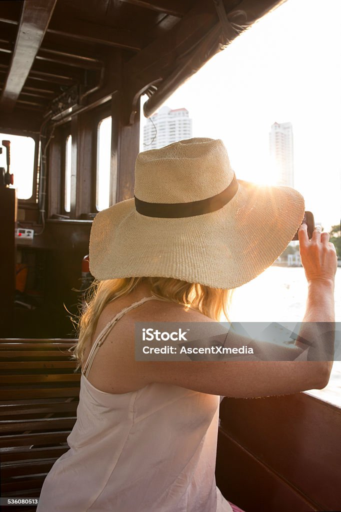 Woman takes pic with smart phone, on river boat Woman takes pic with smart phone, on river boat, Bangkok 2015 Stock Photo