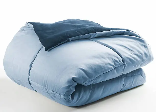 blue folded duvet on a white background