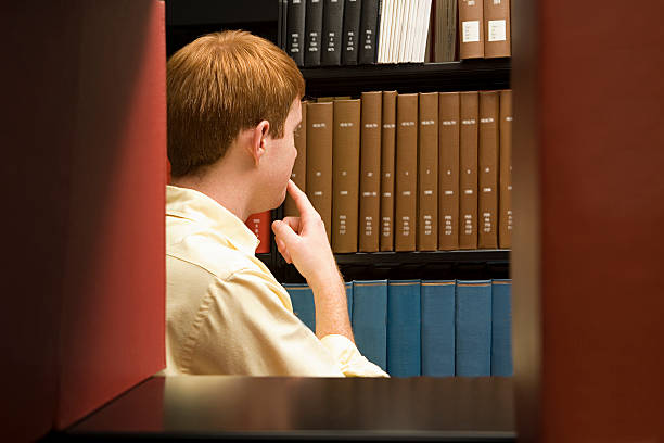 istock Male student choosing a book in the library 536093147