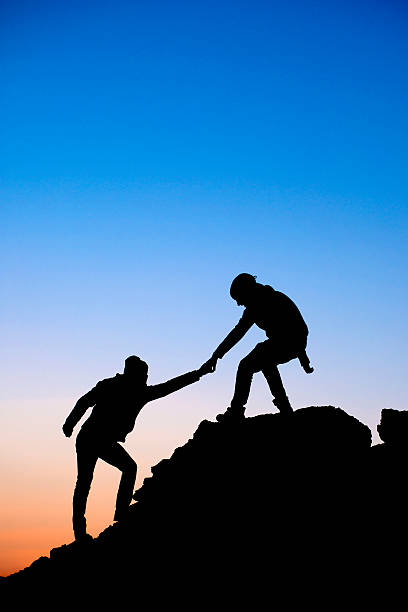 istock Silhouette of helping hand between two climber 536093341