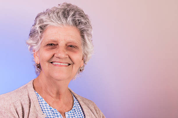 Latin grandmother smiling Latin grandmother smiling wearing cream colored coat and blouse blue and white hispanic grandmother stock pictures, royalty-free photos & images