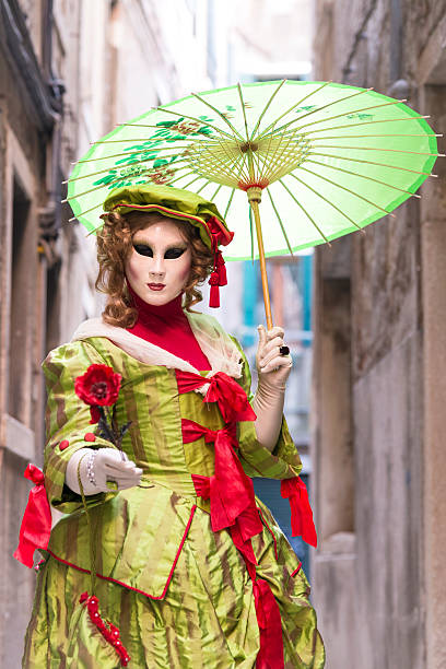 green weibliche maske mit sonnenschirm, karneval von venedig, arsenal, italien, europa - women masquerade mask mardi gras front view stock-fotos und bilder