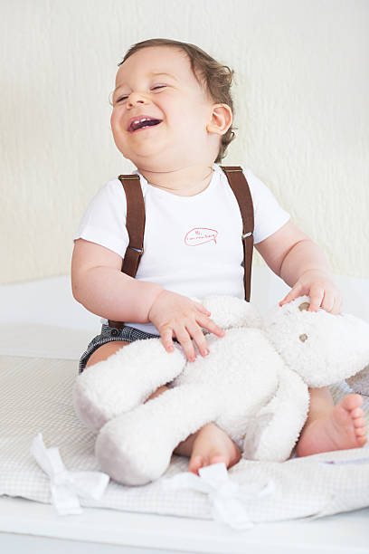 istock Portrait of llitle boy sitting and laughing on light background 536093993