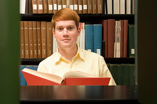 Male student reading in the library