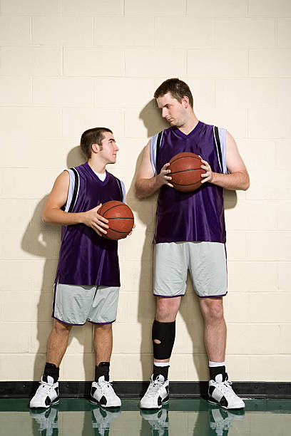 высокие и короткие игроки баскетбола - short tall men couple стоковые фото и изображения