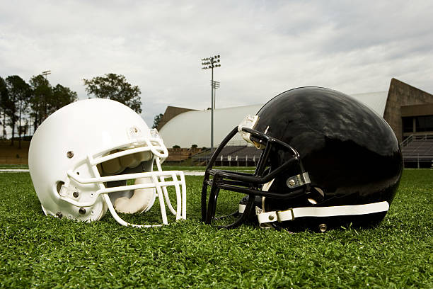 noir et blanc casque de football américain - football helmet playing field american football sport photos et images de collection