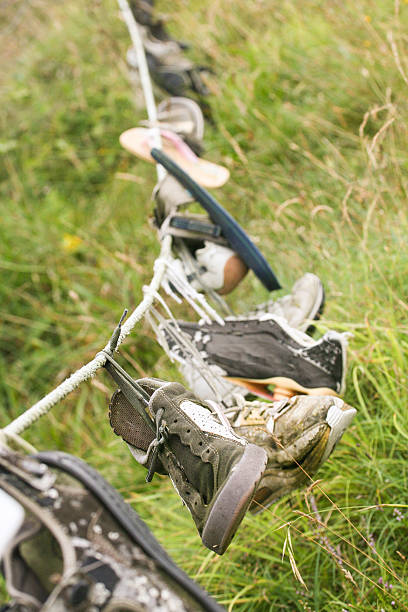 istock Old abandoned shoes and trainers hanging on line  from beach 536109101