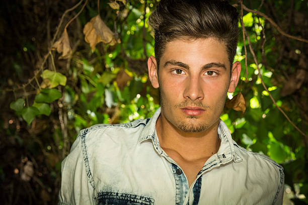 istock Handsome young man looking among plants and bushes 536109463