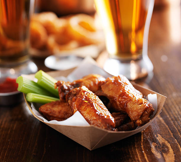 spicy chicken wings with beer in background stock photo