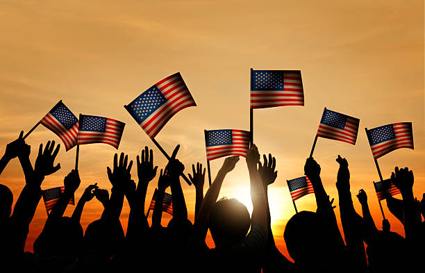 istock Group of People Waving American Flags in Back Lit 536111293