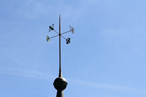 A Golden Weather Vane with an arrow against a clear blue sky