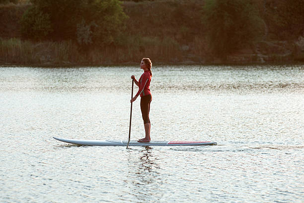 Montreux, Switzerland - August 27, 2016: Girl standing on standup paddle surfing on Geneva Lake in Montreux, Vaud canton, Switzerland