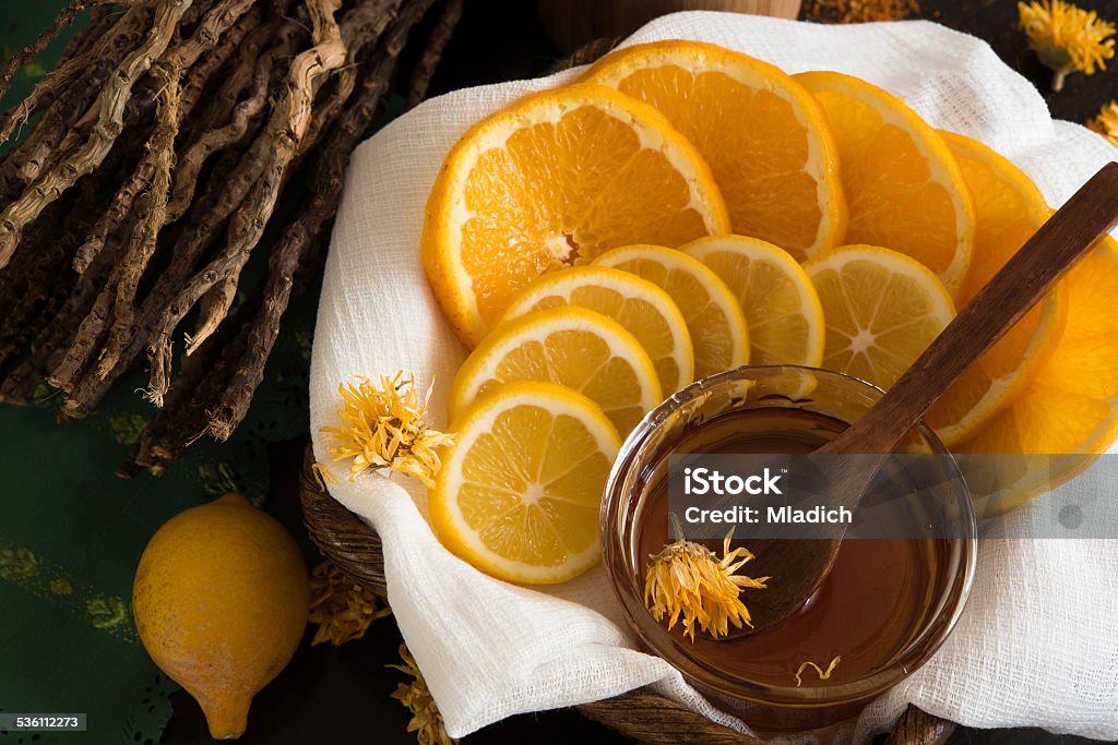 Sliced lemon and orange Sliced lemon and orange, behind is mortar, ginger root and dry branches 2015 Stock Photo