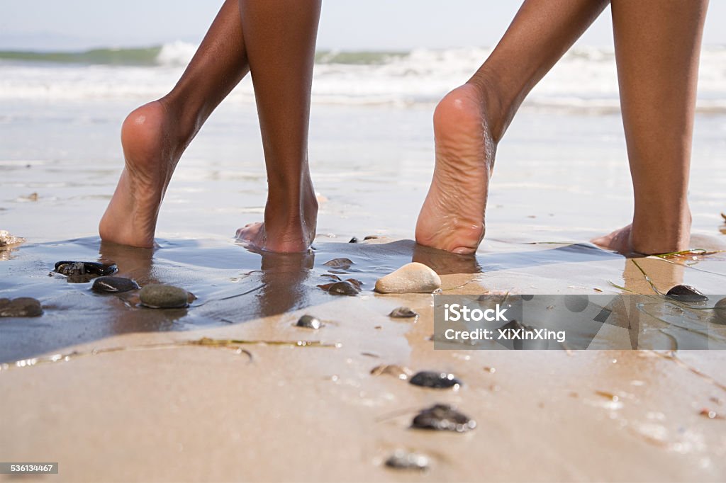 Two people on beach with crossed legs Beach Stock Photo