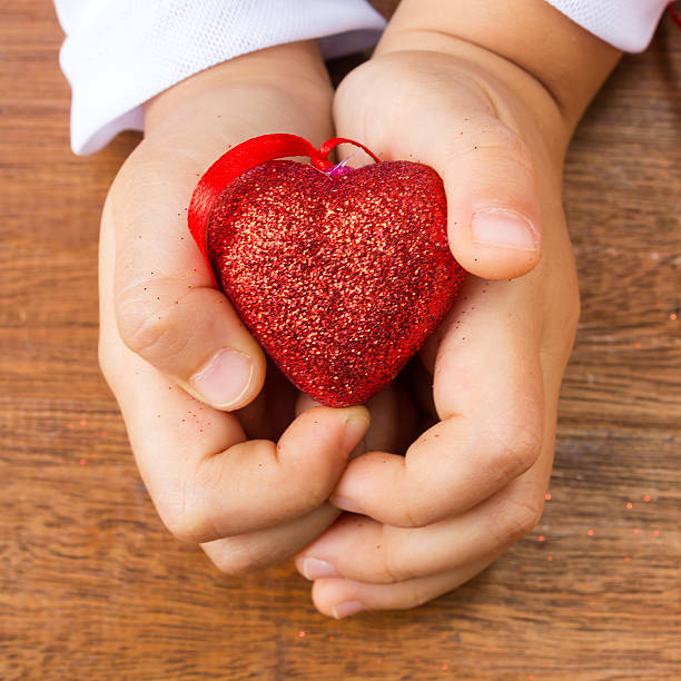 istock Girl's hand holding  a red heart shape. 536134921