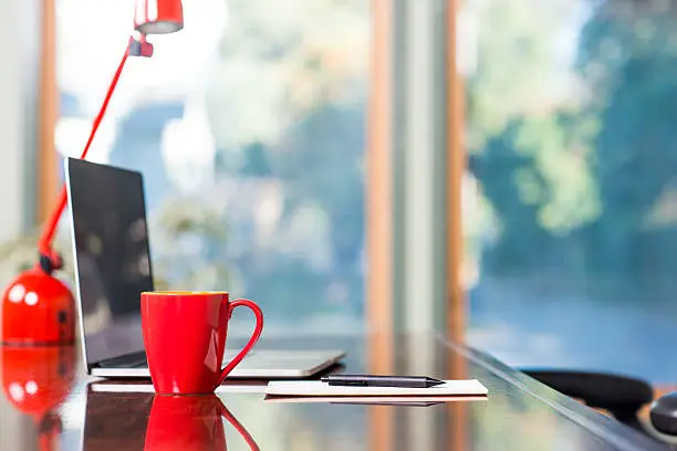 Photo of Desk With Red Coffee Cup
