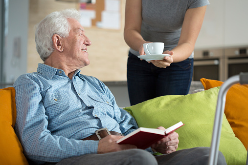 Elderly happy man reading the book and his tea time