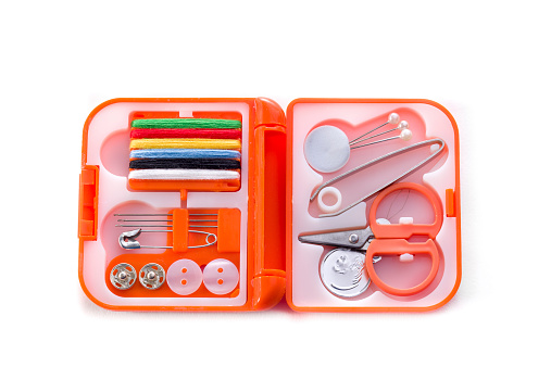 Small sewing kit in an orange case on a white background