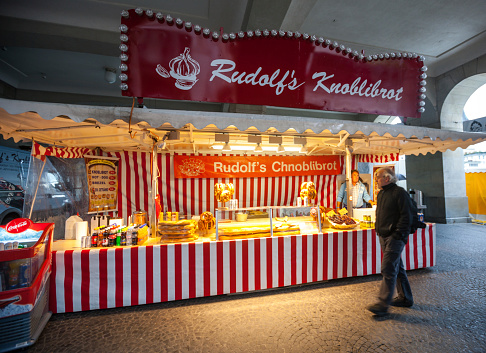 Zurich, Switzerland  - April 28, 2014: Kiosk selling Snacks and bread on Zurich street. Vendor waiting for customers. Man walking nearby