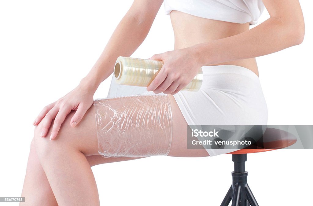 woman wrapping leg with plastic wrapper woman wrapping leg with plastic wrapper for slimming The Human Body Stock Photo