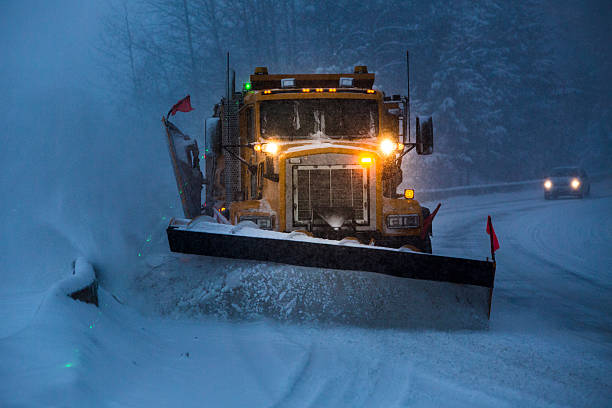 Snowplow plowing the highway during snow storm. stock photo