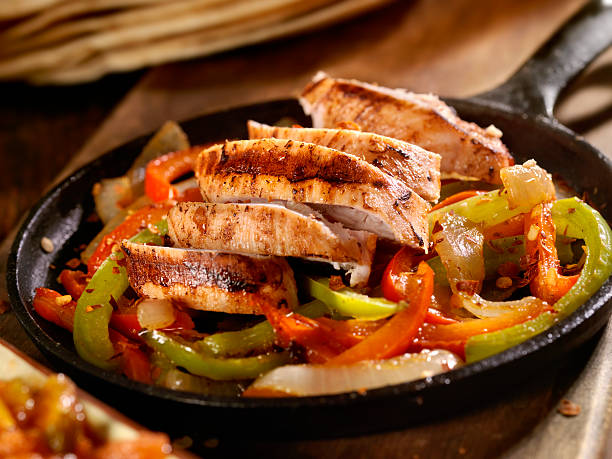 Chicken Fajitas Grilled Chicken Fajitas with Peppers in a Cast Iron Skillet - Photographed on Hasselblad H3D2-39mb Camera fajita photos stock pictures, royalty-free photos & images