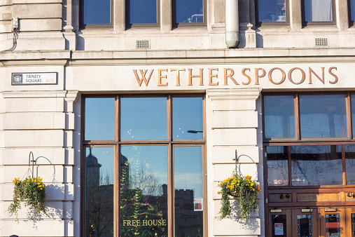 London, England - December 28, 2014: J D Wetherspoons is a restaurant chain established by Tim Martin in 1979. There are more than 800 pubs throughout the UK. Ths one is in Trinity Square on Tower Hill.