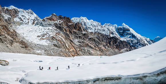 Lobuche, Nepal - 27th October 2011: Mountaineers and Sherpas crossing a snowy glacier on the high altitude Cho La pass below Labuche deep in the Himalaya mountain wilderness of the Sagarmatha National Park, Nepal. Composite panoramic image created from six contemporaneous sequential photographs.