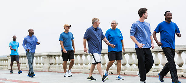 группа мужчины носить синие рубашки, быстрая ходьба - walking exercising relaxation exercise group of people стоковые фото и изображения