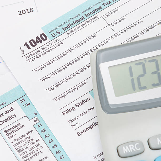 istock Calculator over US 1040 Tax Form - studio shot 536190277