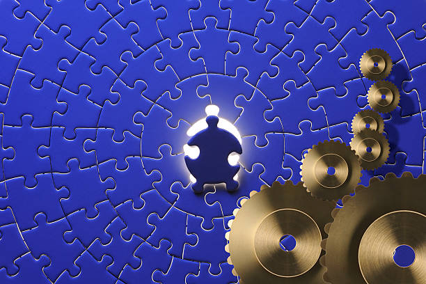dernière pièce du puzzle bleu avec des engrenages en métal sur l'eau - puzzle part of gold jigsaw piece photos et images de collection