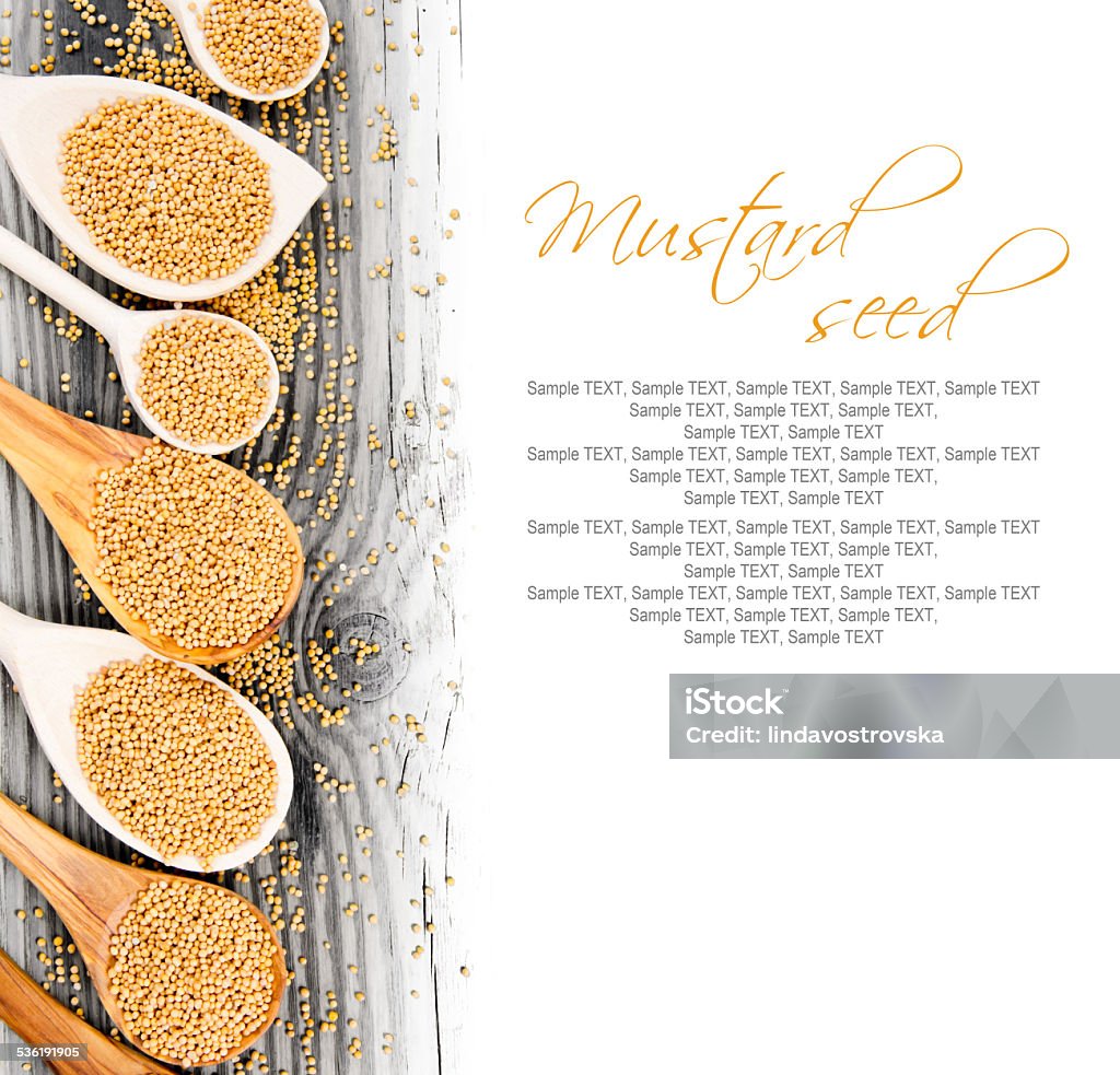 Mustard seed Photo of spoons with mustard seeds on wooden board with white space for text 2015 Stock Photo