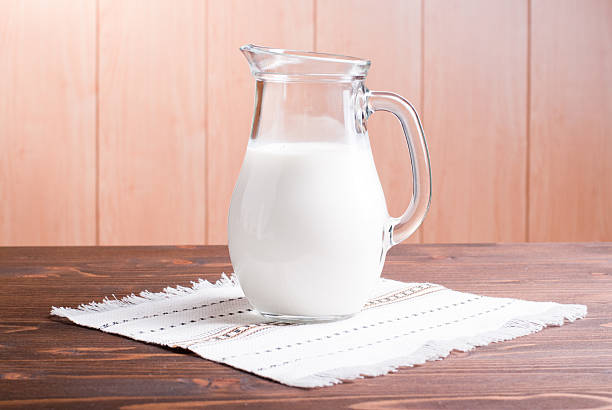 istock jug with milk on a light wooden table side view 536192963