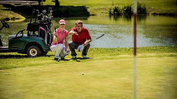 ゴルフプロゴルファーによる雌 - golf golf course putting men ストックフォトと画像