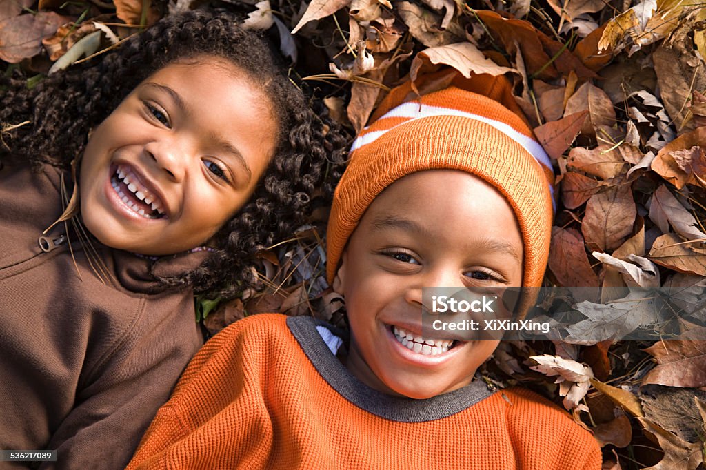 Kids lying on leaves Autumn Stock Photo