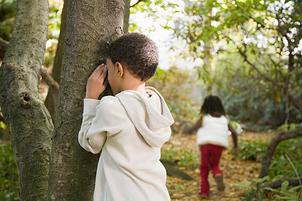 Children playing hide and seek Children playing hide and seek flower outdoors day loving stock pictures, royalty-free photos & images