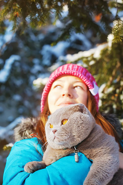 istock cat and young woman playing in winter 536217469