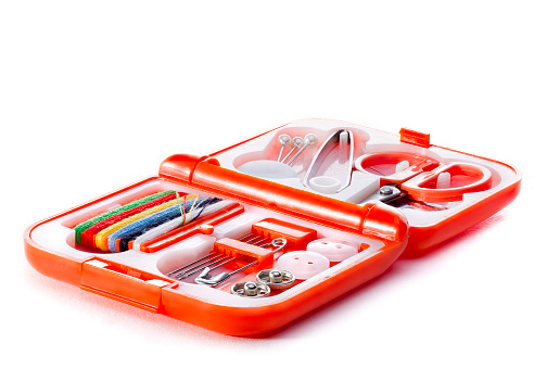 Small sewing kit in an orange case on a white background