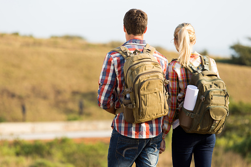 back view of couple holding hands on top of mountain