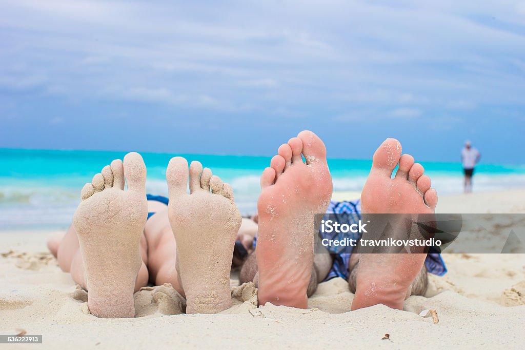 Closeup male and female feet on white sand Close up male and female feet on white sand beach Adult Stock Photo