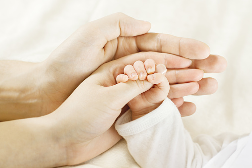 Family and Newborn Baby Hands, Mother Father Children Body, Embrace Newborn Kid Hand. Family Helping Hand, Care and Love Concept.