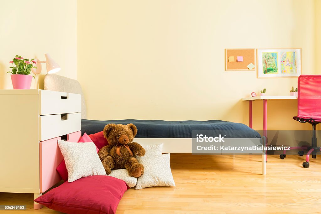 Mascot on pillows Cute children mascot on colorful pillows in bedroom Childhood Stock Photo