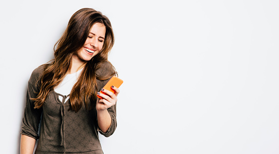 Young girl having fun, chating on her phone.