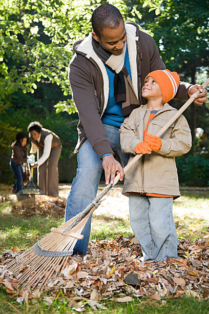 família raking folhas - family african ethnicity black african descent imagens e fotografias de stock