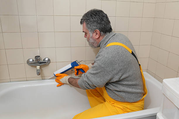 istock Worker caulking bath tube and tiles 536250061